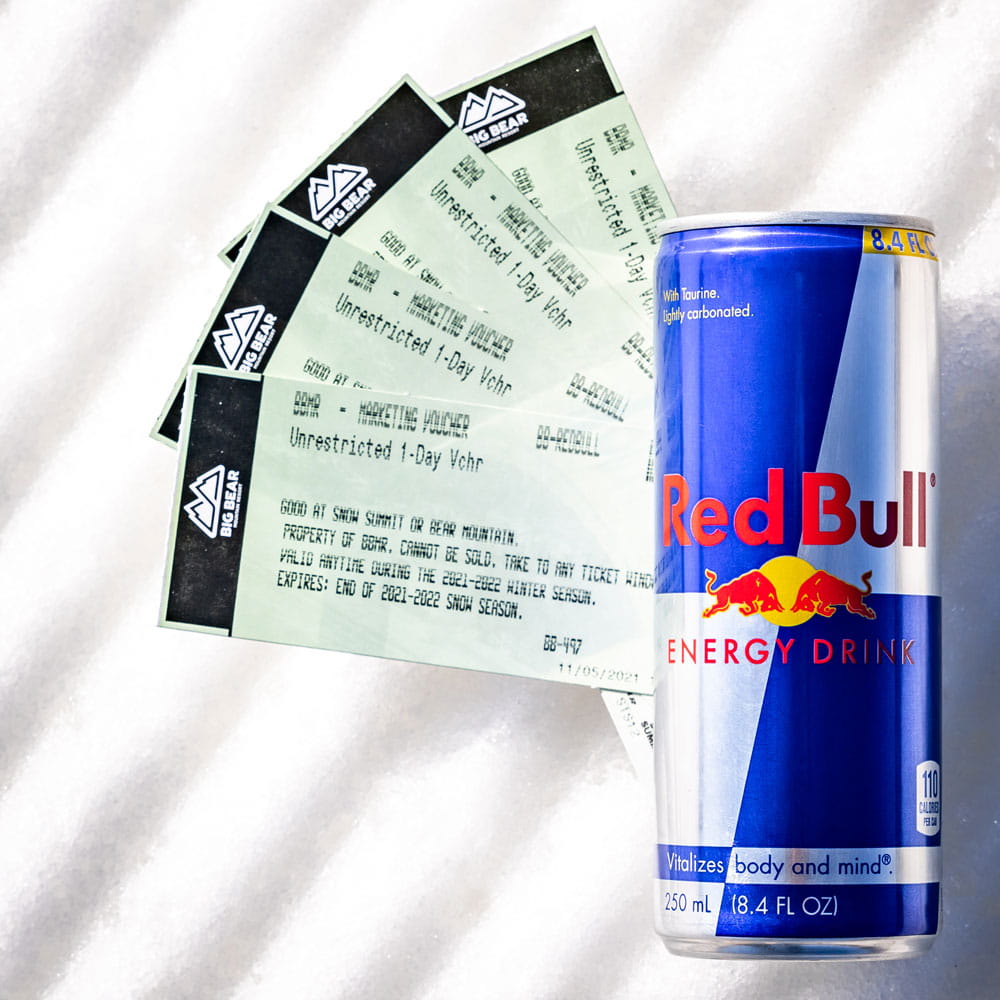 redbull can with 4 big bear mountain resort tickets lying on the snow
